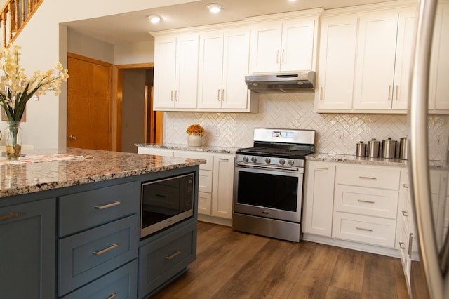 kitchen with stainless steel gas range, under cabinet range hood, white cabinets, tasteful backsplash, and built in microwave