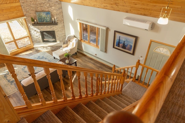 staircase featuring a wall unit AC, a fireplace, wooden ceiling, and wood finished floors