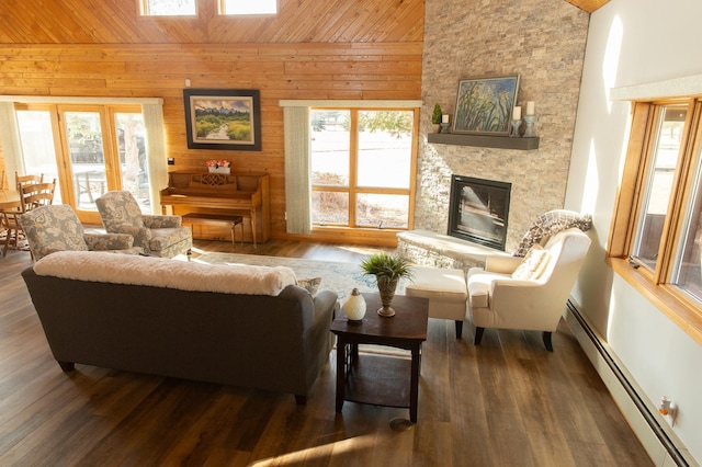 living area featuring a baseboard heating unit, vaulted ceiling, wood ceiling, wood walls, and a fireplace