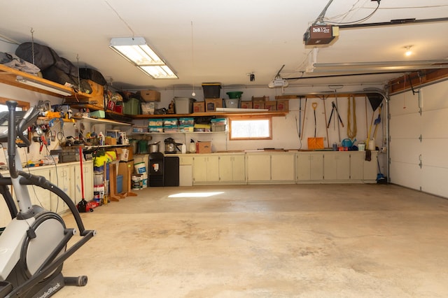 garage with a garage door opener and a workshop area