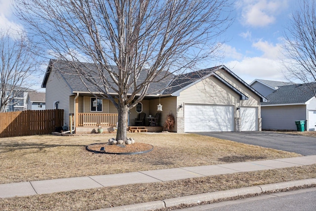 ranch-style house featuring aphalt driveway, a porch, fence, an attached garage, and a shingled roof