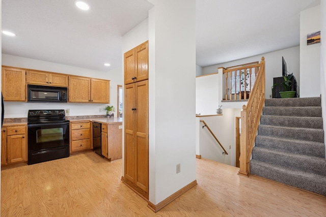 kitchen with recessed lighting, light wood-style floors, and black appliances