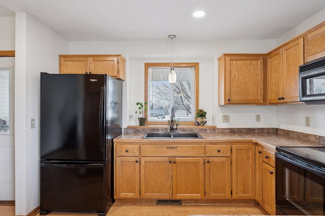 kitchen featuring visible vents, recessed lighting, a sink, black appliances, and decorative light fixtures