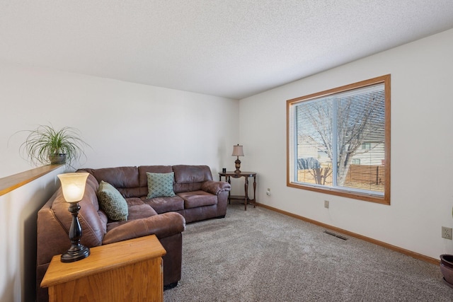 living room featuring visible vents, baseboards, a textured ceiling, and carpet flooring