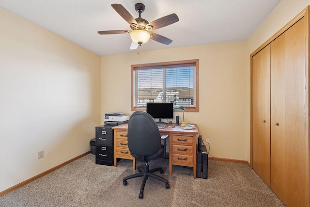 office featuring light carpet, ceiling fan, and baseboards