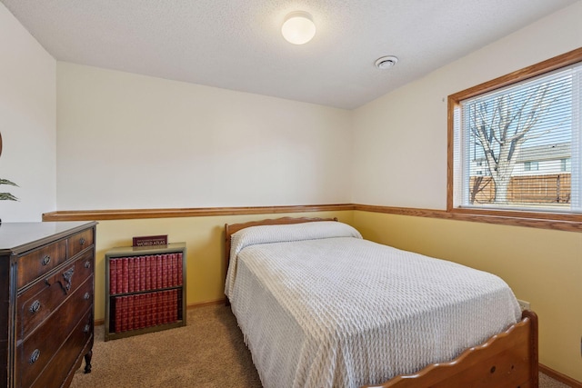 carpeted bedroom with visible vents, baseboards, and a textured ceiling