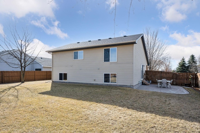 back of house with a yard, a fenced backyard, and a patio