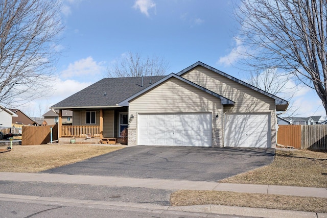 single story home with aphalt driveway, a porch, fence, roof with shingles, and an attached garage