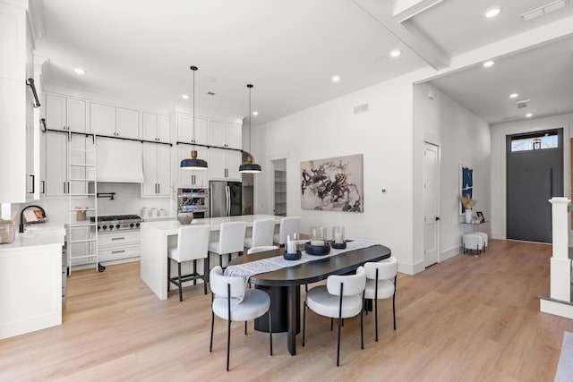 dining space with light wood-type flooring, baseboards, visible vents, and recessed lighting