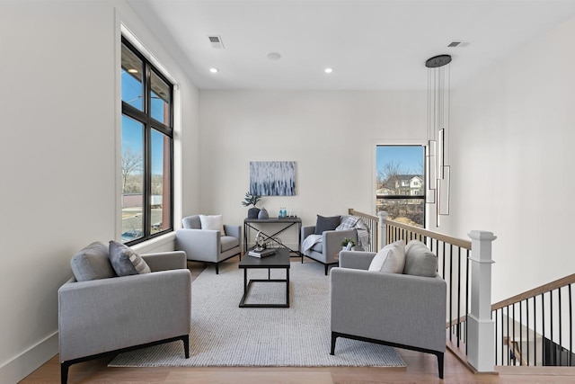 living room with baseboards, visible vents, wood finished floors, and recessed lighting