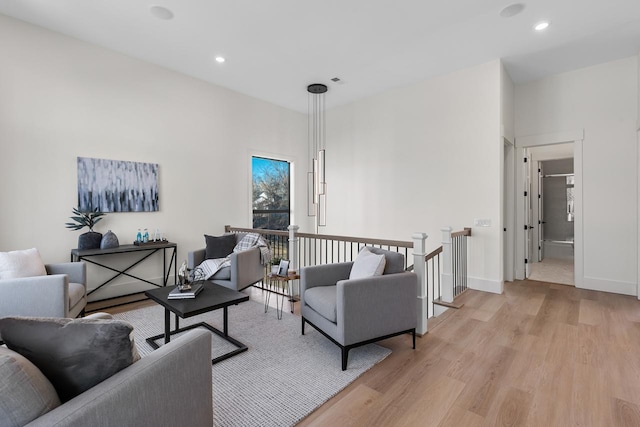 living area with light wood-style flooring, baseboards, and recessed lighting