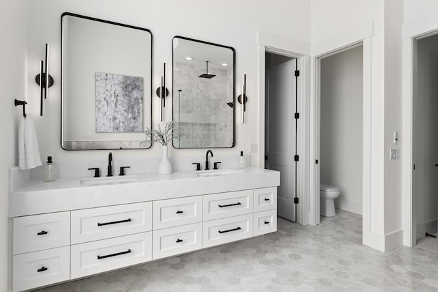 full bathroom with a sink, a shower stall, toilet, and double vanity