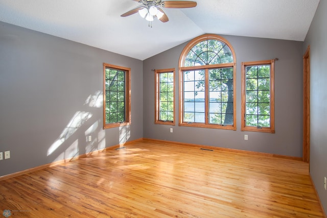 unfurnished room with ceiling fan, baseboards, lofted ceiling, and wood finished floors