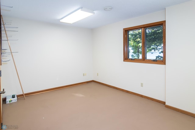 carpeted empty room featuring baseboards