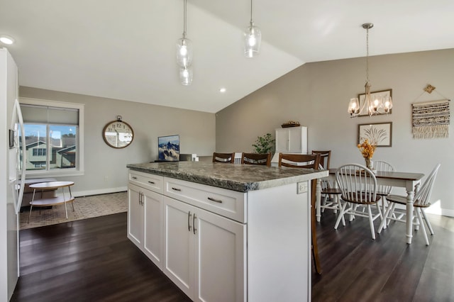 kitchen featuring dark wood-style flooring, a kitchen island, white cabinetry, vaulted ceiling, and dark countertops