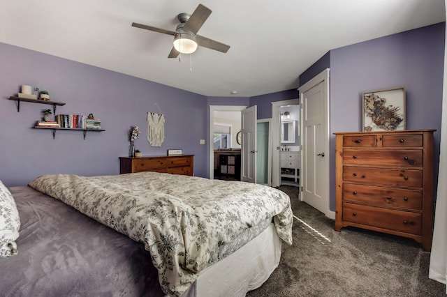 bedroom with ceiling fan, dark colored carpet, and connected bathroom