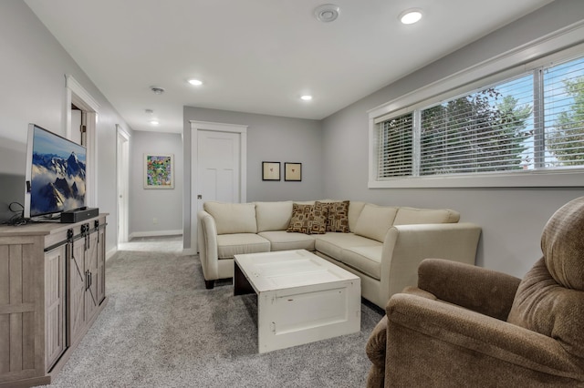 living area featuring baseboards, recessed lighting, and light colored carpet