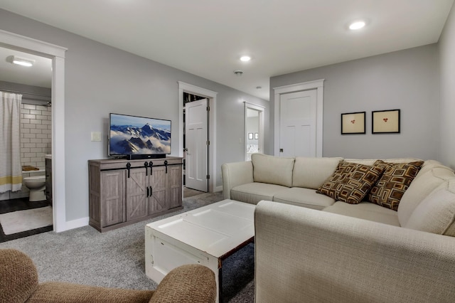 carpeted living area with recessed lighting and baseboards