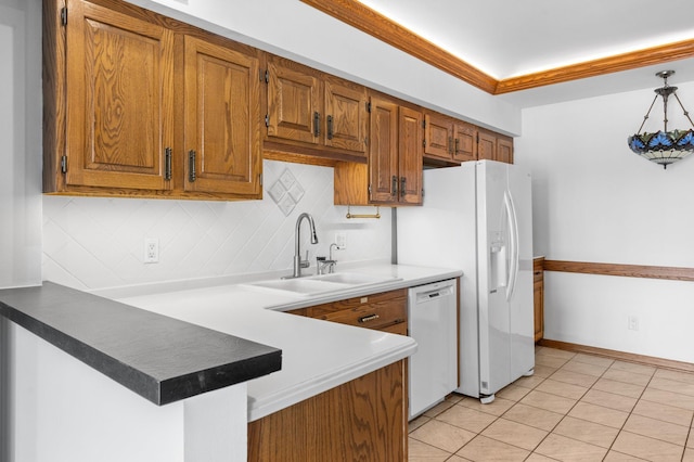 kitchen featuring decorative backsplash, white appliances, brown cabinets, and a sink