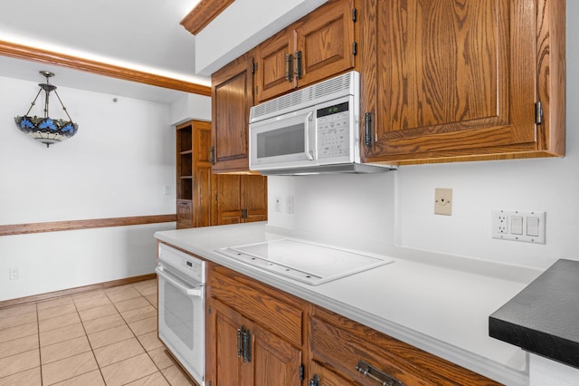 kitchen featuring white appliances, brown cabinetry, baseboards, light tile patterned flooring, and light countertops