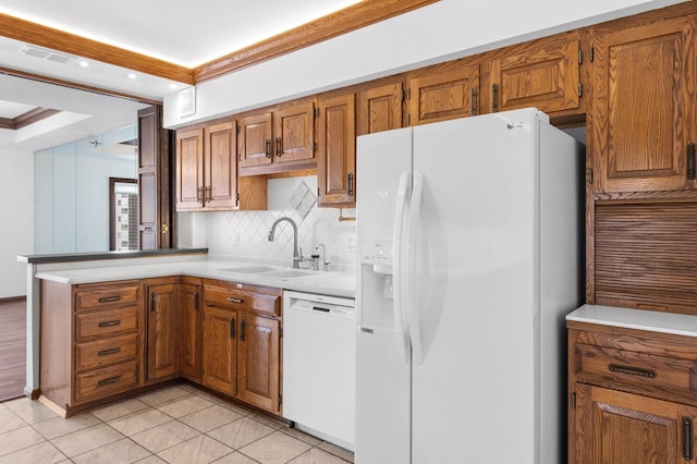 kitchen with visible vents, brown cabinets, white appliances, and a sink