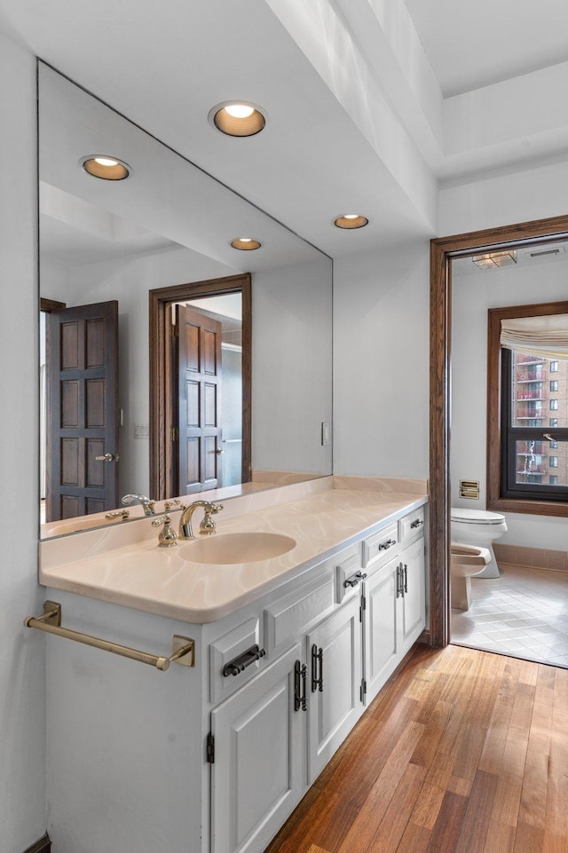 bathroom featuring recessed lighting, toilet, wood finished floors, and vanity