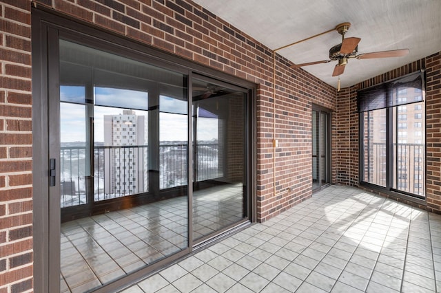 unfurnished sunroom featuring ceiling fan