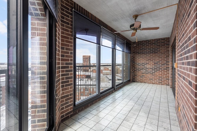 unfurnished sunroom with a city view and a ceiling fan