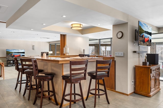 bar featuring recessed lighting, wet bar, and baseboards