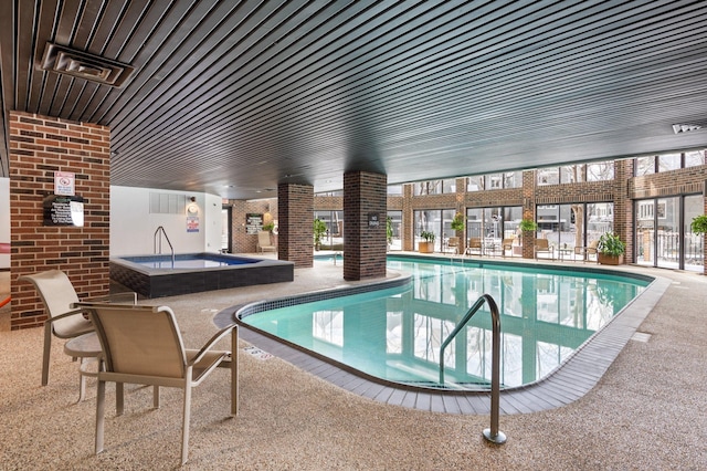 community pool with an indoor in ground hot tub and a patio area