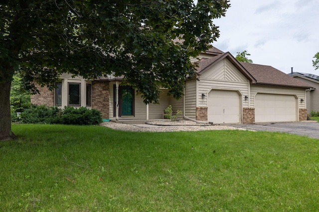 obstructed view of property with a garage, driveway, a front lawn, and brick siding