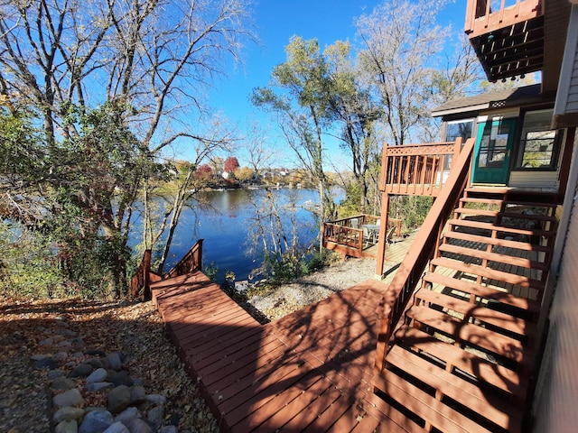 dock area with stairs and a deck with water view