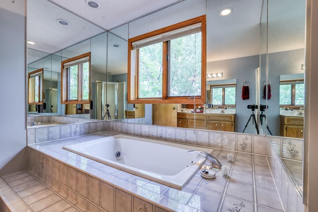 full bathroom featuring a jetted tub, recessed lighting, vanity, and a stall shower