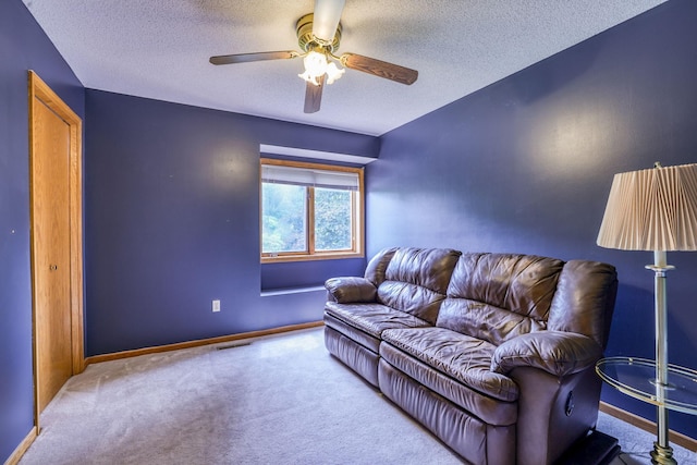 carpeted living room with a textured ceiling, ceiling fan, visible vents, and baseboards