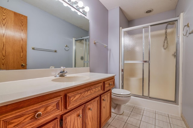 bathroom featuring a stall shower, vanity, toilet, and tile patterned floors