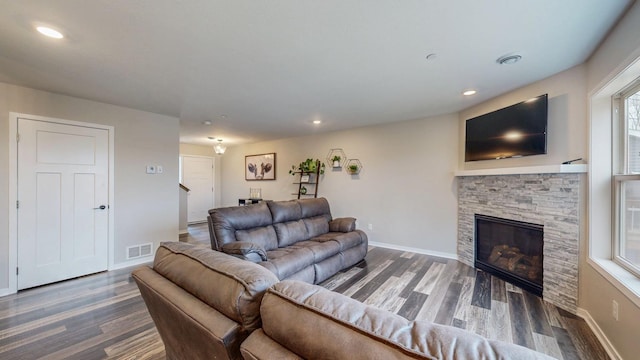 living area with wood finished floors, visible vents, baseboards, a fireplace, and recessed lighting