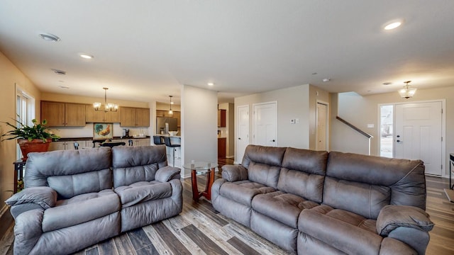 living area with recessed lighting, dark wood-type flooring, and an inviting chandelier