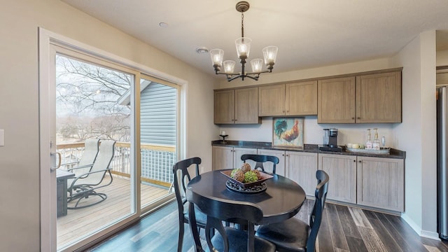 dining space with baseboards, dark wood-type flooring, and an inviting chandelier