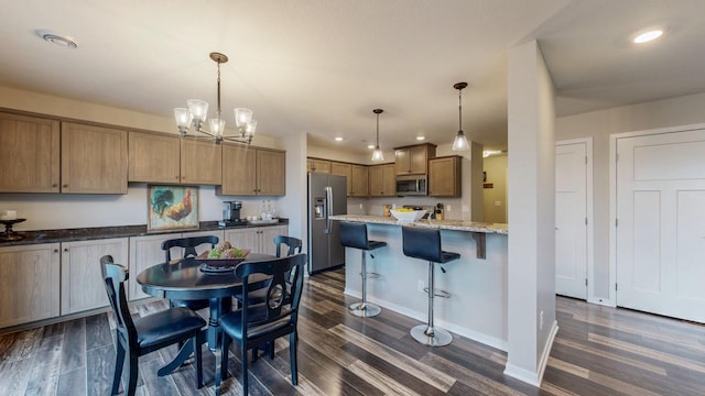 kitchen featuring recessed lighting, stainless steel appliances, a kitchen breakfast bar, and dark wood-style flooring