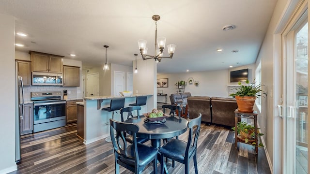 dining area with recessed lighting, baseboards, dark wood-type flooring, and an inviting chandelier