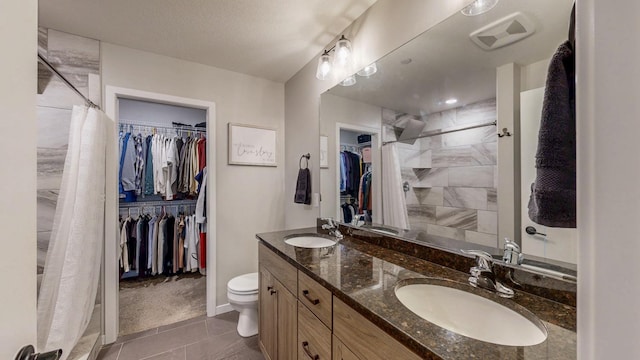 full bath featuring double vanity, visible vents, toilet, and a sink