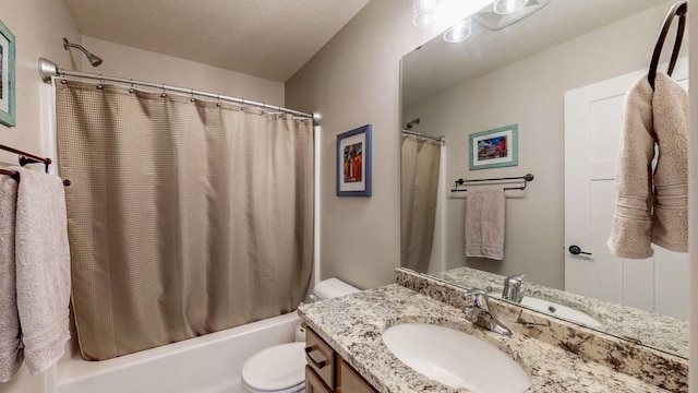 bathroom with vanity, toilet, shower / tub combo with curtain, and a textured ceiling