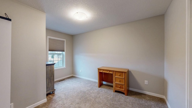 unfurnished room featuring a textured ceiling, baseboards, and carpet