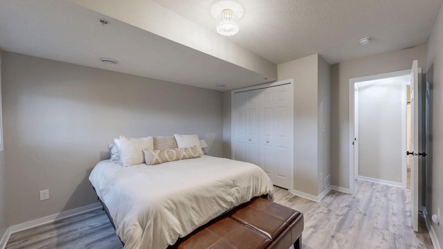 bedroom with a closet, baseboards, and light wood-style flooring