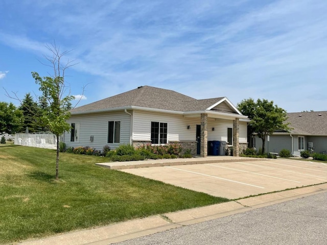 ranch-style home featuring a front yard, uncovered parking, and roof with shingles