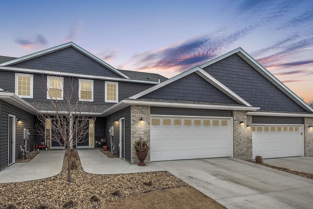 view of front facade with brick siding, concrete driveway, and a garage