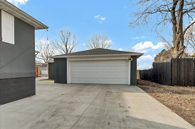 detached garage featuring fence