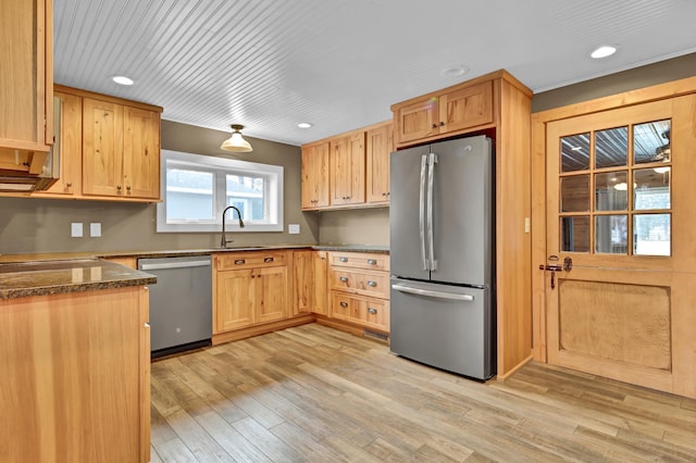 kitchen with dark countertops, stainless steel appliances, light wood-type flooring, a sink, and recessed lighting