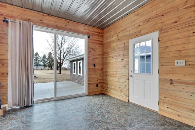 entryway with wood walls and stone finish flooring