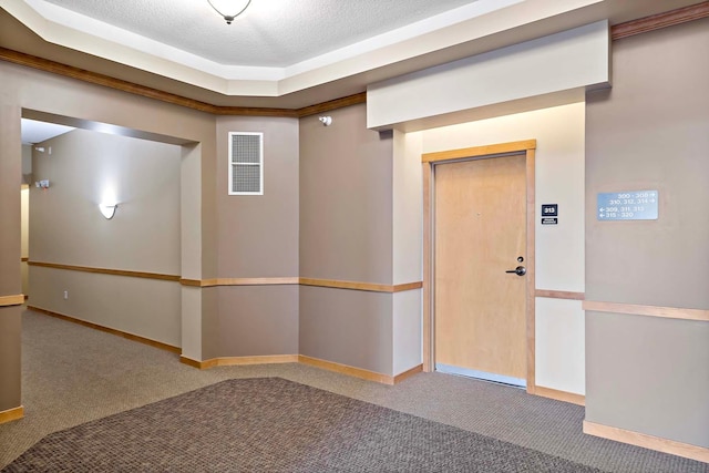 interior space with carpet flooring, baseboards, visible vents, and a textured ceiling